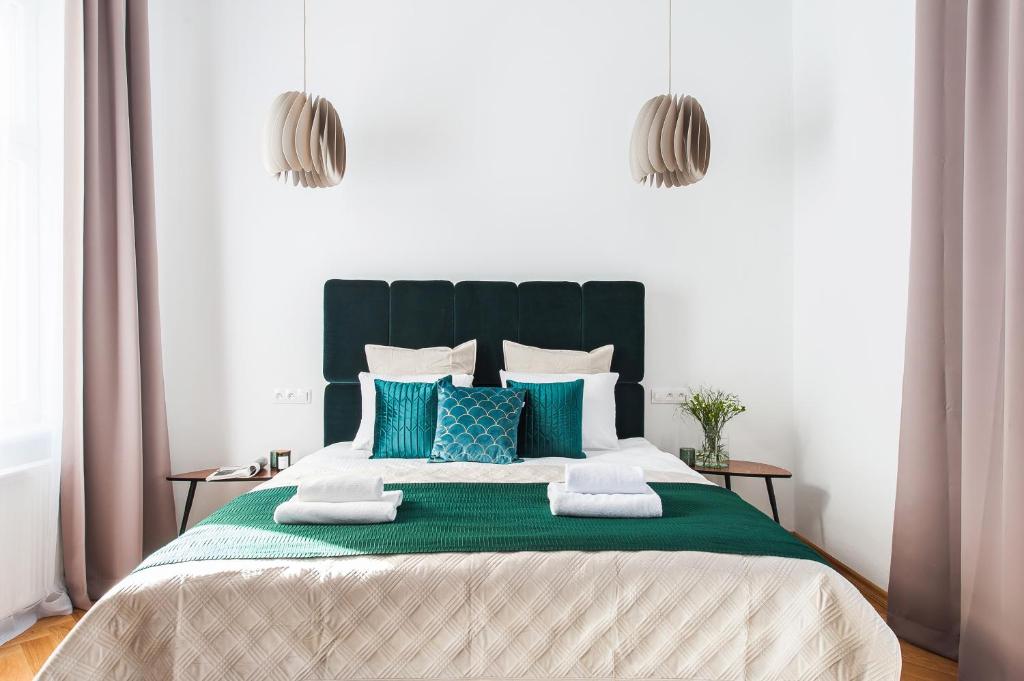 une chambre avec un grand lit avec des oreillers bleus dans l'établissement Cracovian Home - LoftAffair, à Cracovie