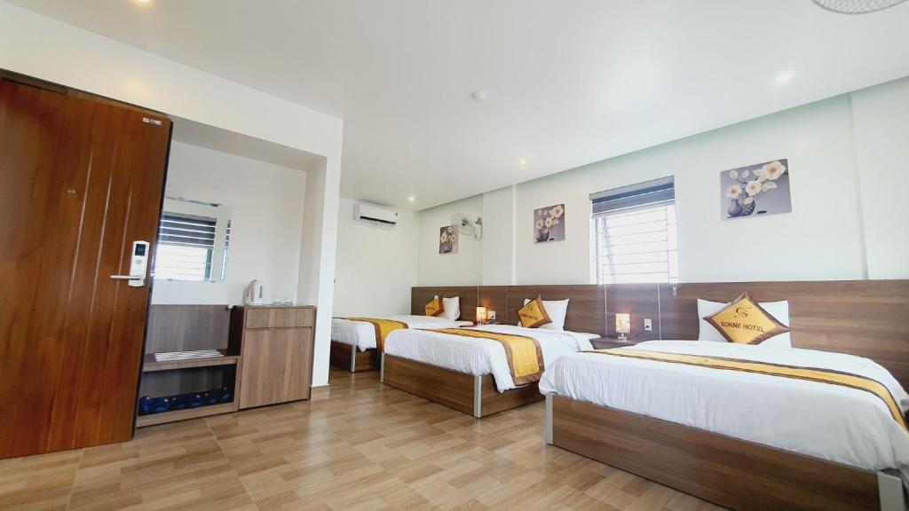 a hotel room with two beds and a television at Sonne Hotel Quang Binh in Ðộng Hỏi