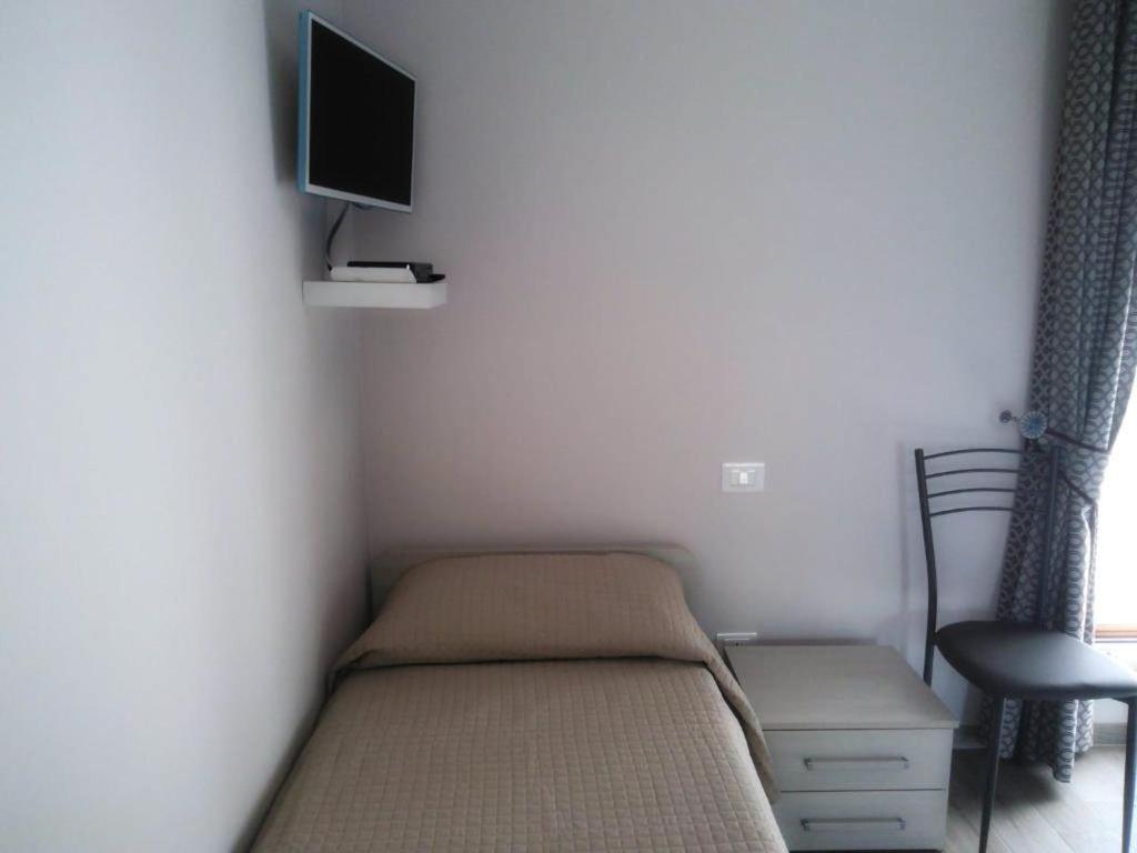 a small bedroom with a bed and a tv on the wall at B&B Tirassegno in Agnone