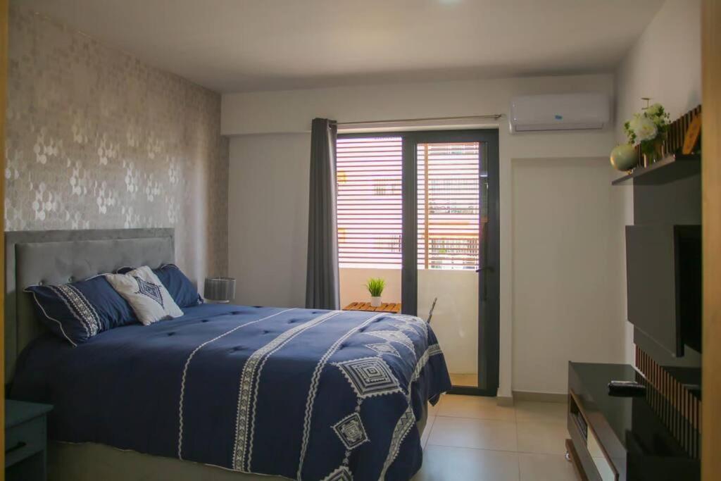 Un dormitorio con una cama azul y una ventana en Brand new, with private Jacuzzi en Carlos Guerra