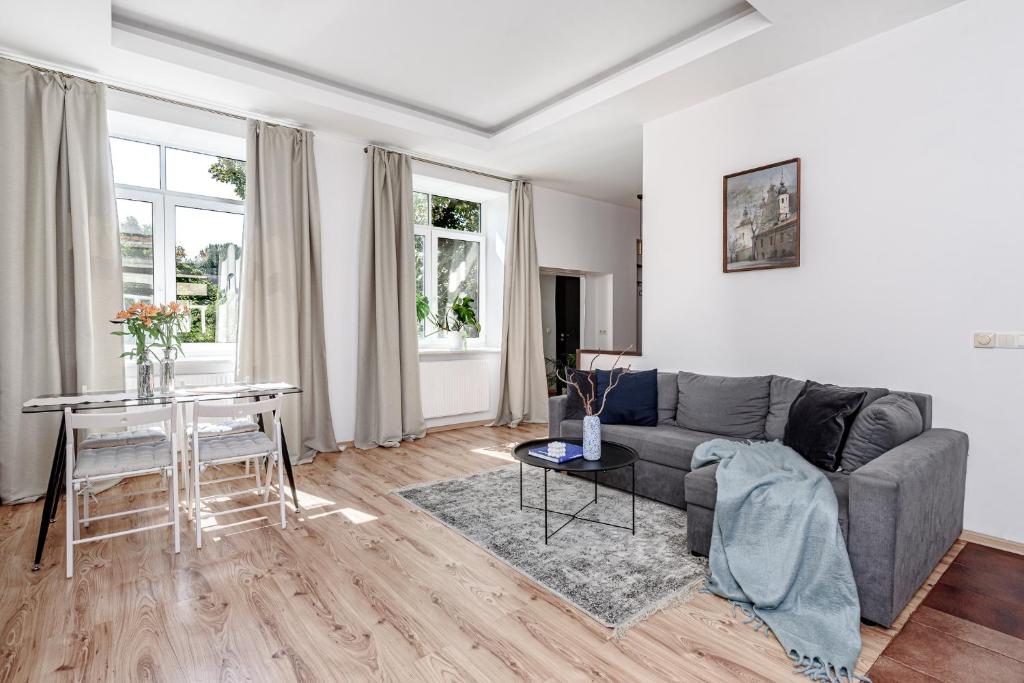 een woonkamer met een bank en een tafel bij Spacious City Centre Apartment with Parking SELF CHECK-IN in Vilnius