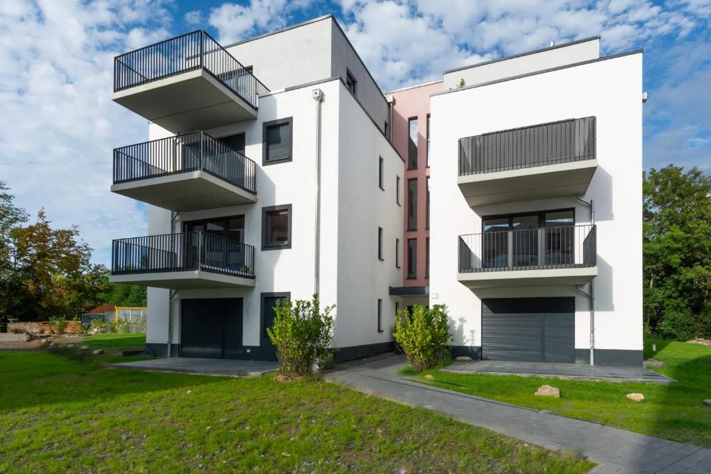 - un bâtiment blanc avec un balcon et une cour dans l'établissement T&K Apartments - Bergisch Gladbach - 7 Comfortable Apartments - 20 min to Fair Messe Cologne, à Bergisch Gladbach