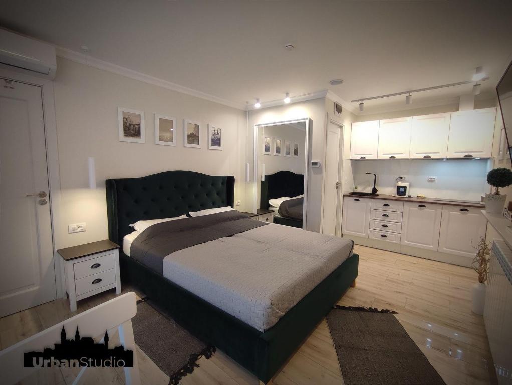a bedroom with a large bed and a kitchen at Urban Studio - Self Check-in in Hunedoara