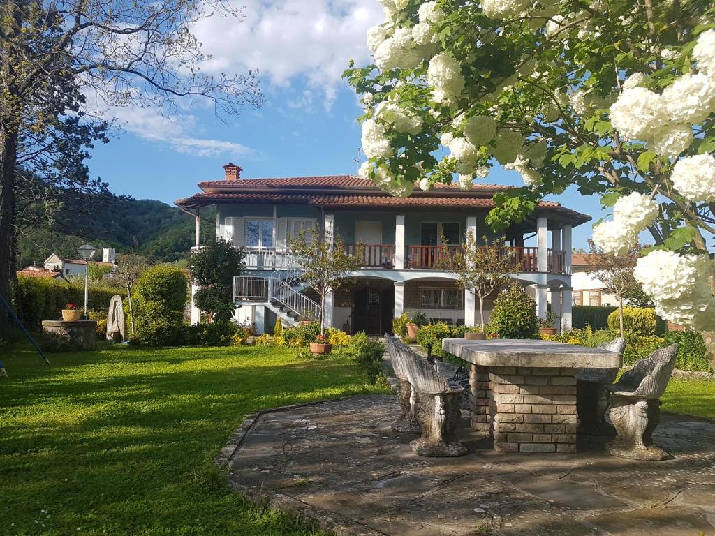 een huis met een stenen bank in de tuin bij Villa Azzurrina in Filettole