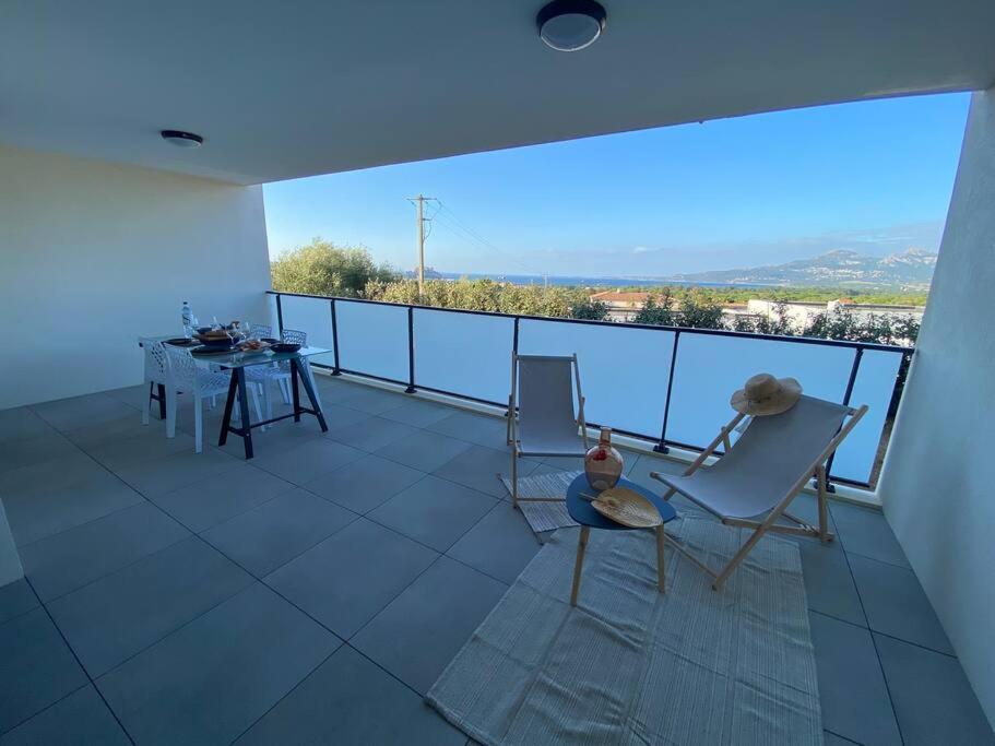 a balcony with a table and chairs and a view at Exceptionnelle Vue Mer Calvi - Piscine - T2 in Calvi