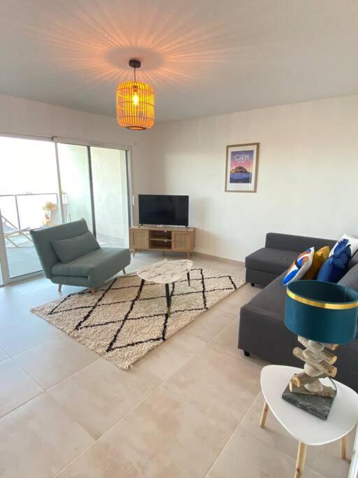 a living room with a couch and a chair at Exceptionnelle Vue Mer Calvi - Piscine - T2 in Calvi