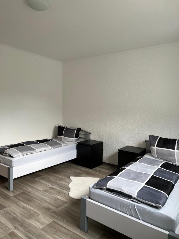 2 camas en una habitación con suelo de madera en F&M Wohnungen in Olpe, en Olpe