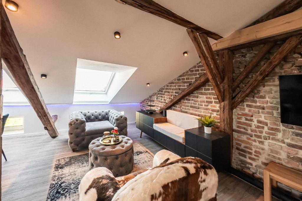 a living room with a brick wall at CREST - Riverside Lofts mit Whirlpool & Wanne I Parken I Balkon I Netflix I Küche in Passau