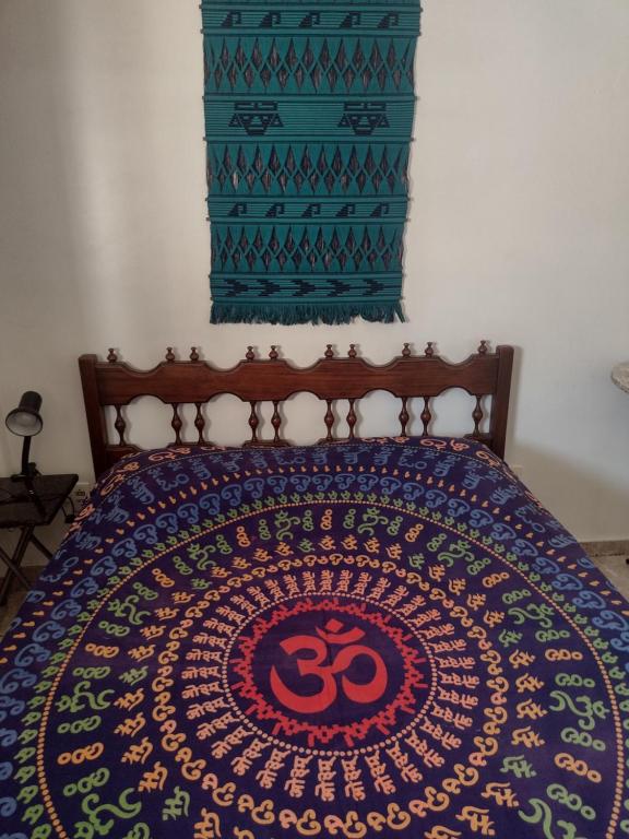 1 dormitorio con 1 cama con colcha colorida en Loft encantador centro Guarapari en Guarapari