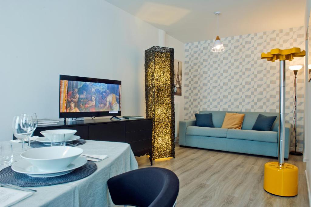 Una sala de estar con un sofá azul y un televisor. en Como per Voi-Tre minuti dal lago, en Como