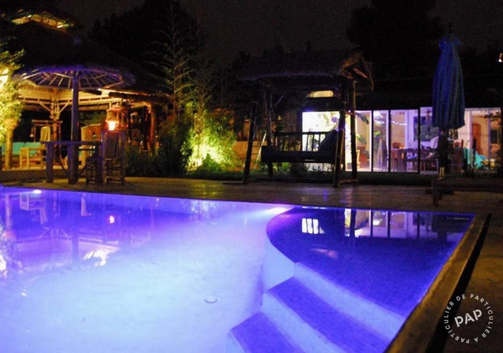 ein Pool in der Nacht mit violetten Lichtern in der Unterkunft Bambou house in Cabriès