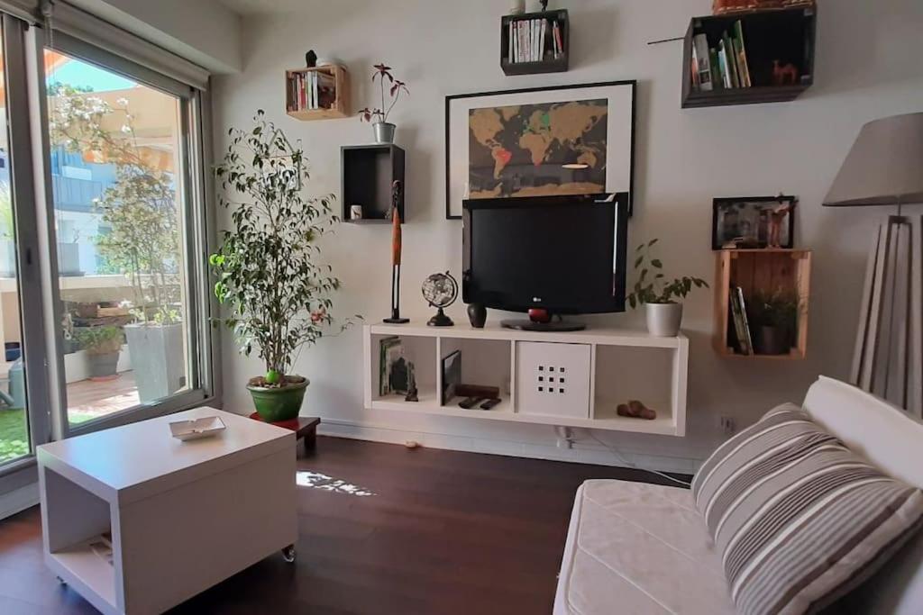 un salon avec un canapé et une télévision dans l'établissement Le Monspetellarius (parking, terrasse & clim), à Montpellier