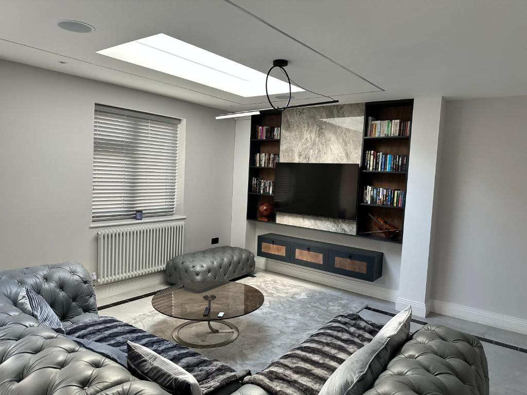 a living room with a couch and a tv at A super luxury large apartment in Barnet