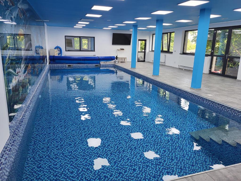 a swimming pool with white rocks in the water at Casa Dana Scorțeni 