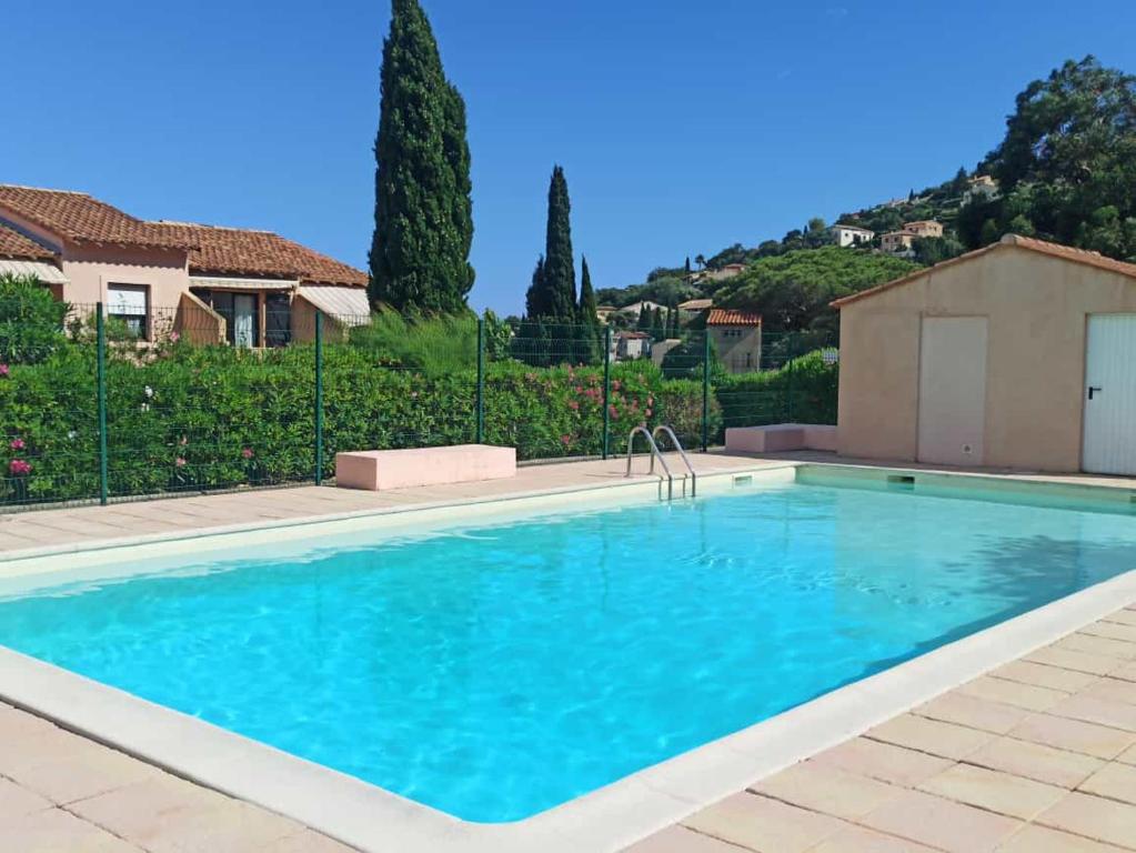 a large swimming pool with blue water in a yard at Appartement avec piscine in Cavalaire-sur-Mer