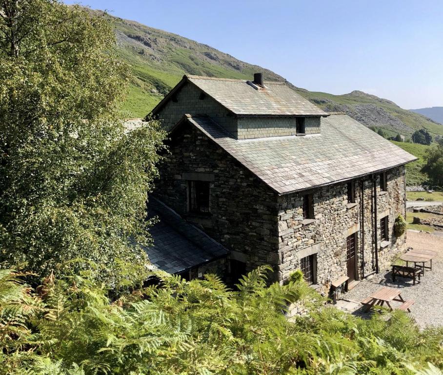 an old stone house with a slate roof at The Mountain Cottages - Millrace in Coniston