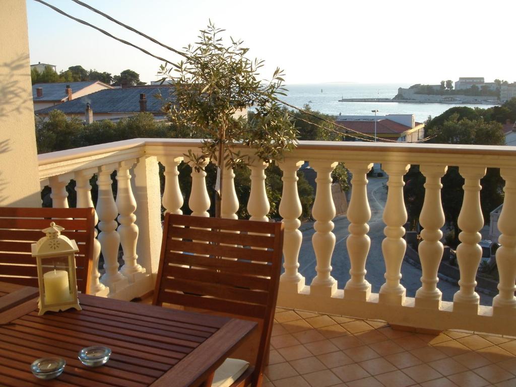 een balkon met een tafel en uitzicht op de oceaan bij Villa Delina in Rab