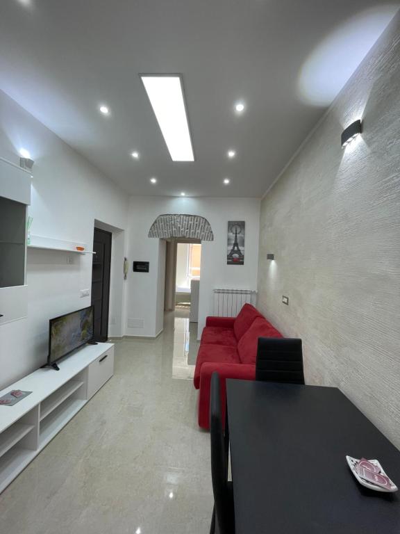 a living room with a red couch and a tv at Casa vacanza l’archetto in Genzano di Roma