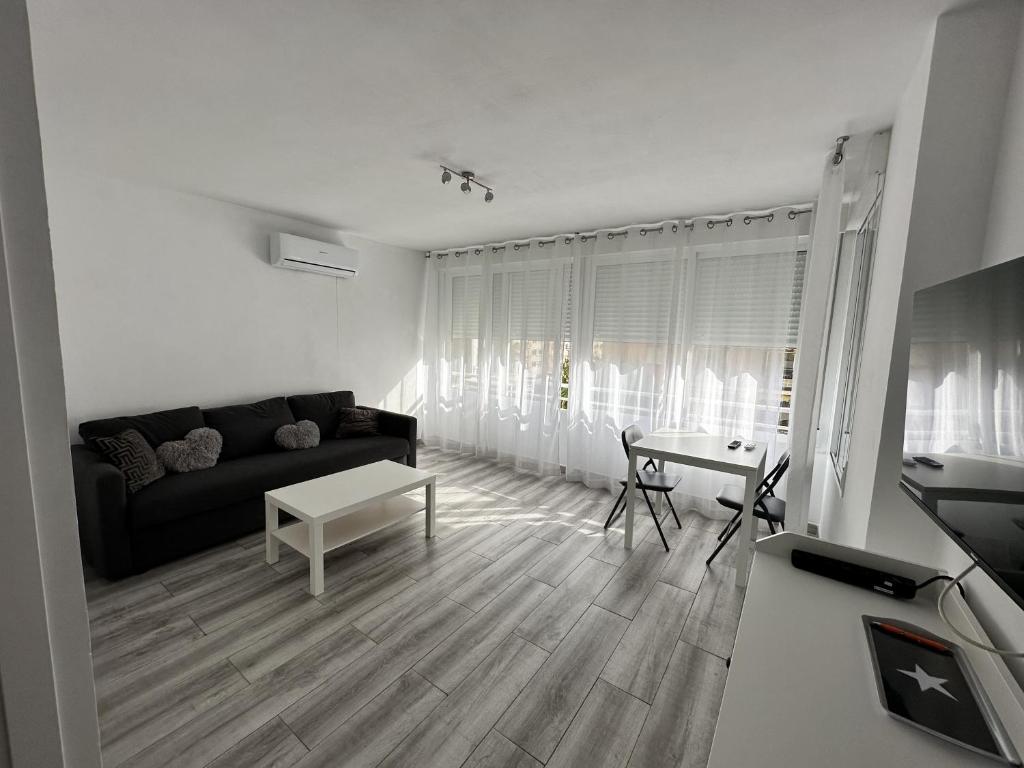 a living room with a black couch and a table at CG4N - Nuevo Estudio, recién reformado, Wifi in Torremolinos