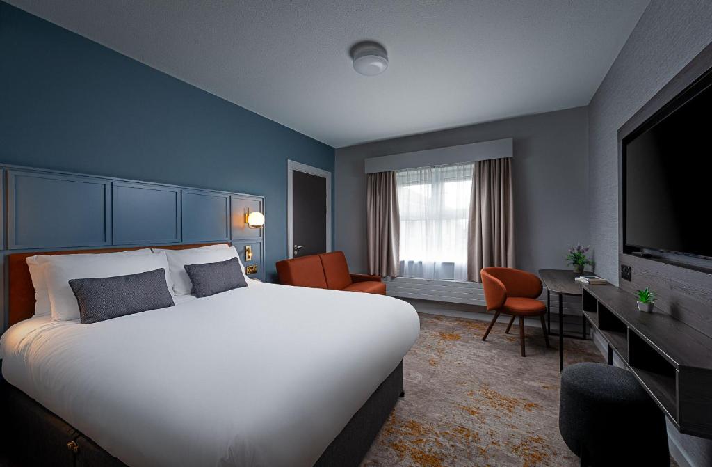 ゴールウェイにあるLeonardo Hotel Galwayの大型ベッドとテレビが備わるホテルルームです。