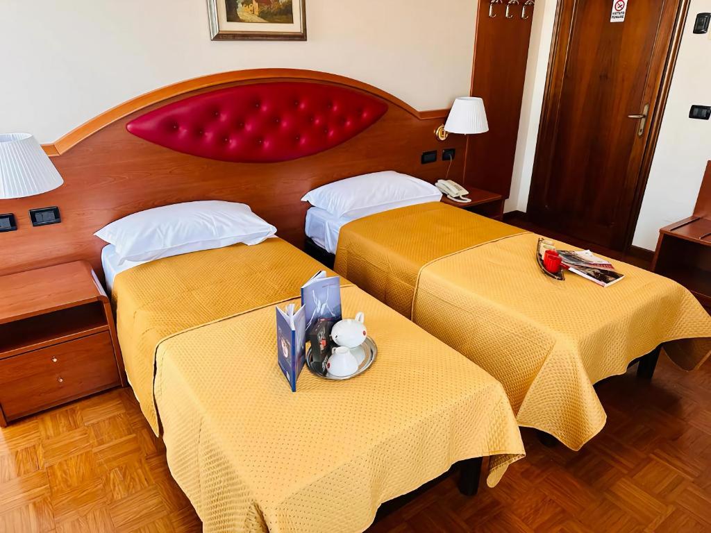 una camera d'albergo con due letti con lenzuola gialle di B&B Banatium a Tezze sul Brenta