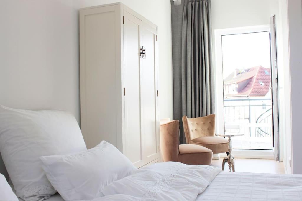1 dormitorio con cama, ventana y silla en Beautiful terrace apartment in Bad Soden, en Bad Soden am Taunus