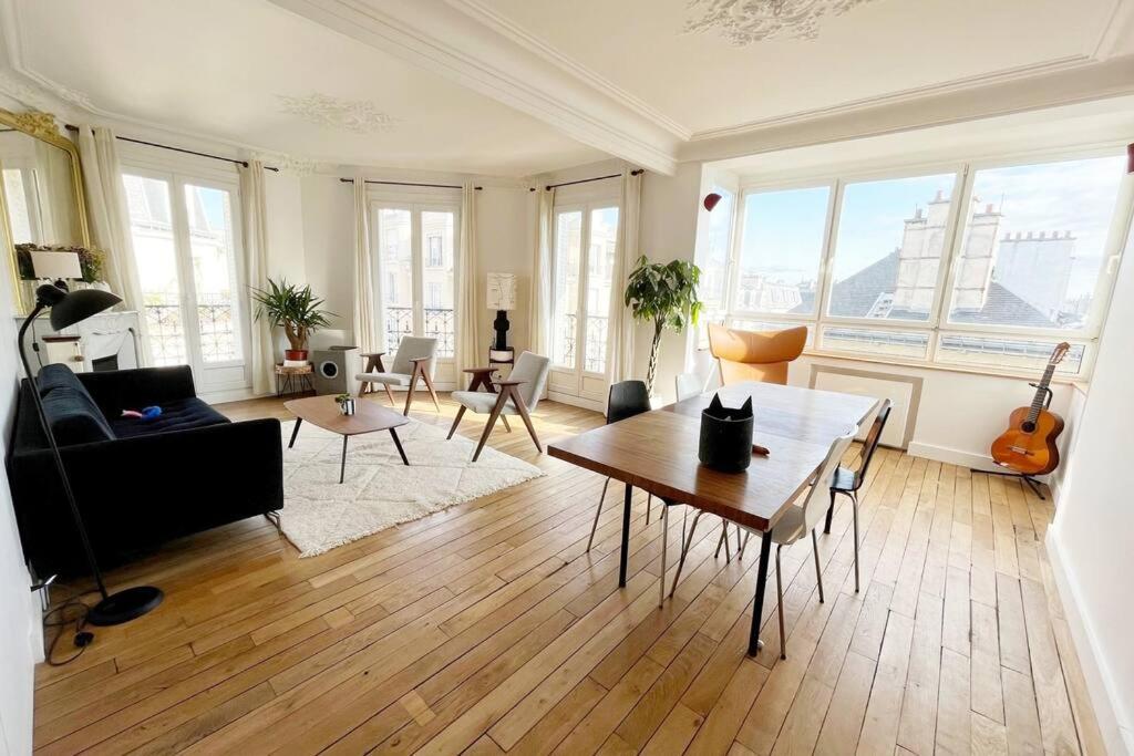 uma sala de estar com um sofá e uma mesa em Appartement au pied de Montmartre / Jules Joffrin em Paris