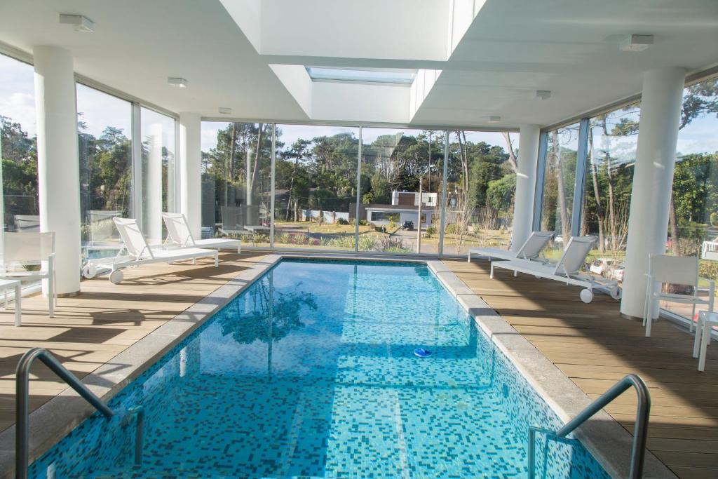 una gran piscina con sillas y una piscina en Oceana Suites en Bellagio Tower, con piscina interior climatizada, en Punta del Este