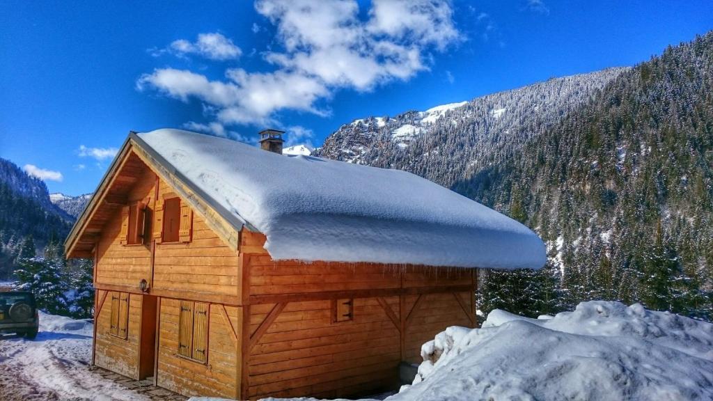 シャテルにあるRefuge Du Lingaの屋根に雪が積もる小さな木造キャビン
