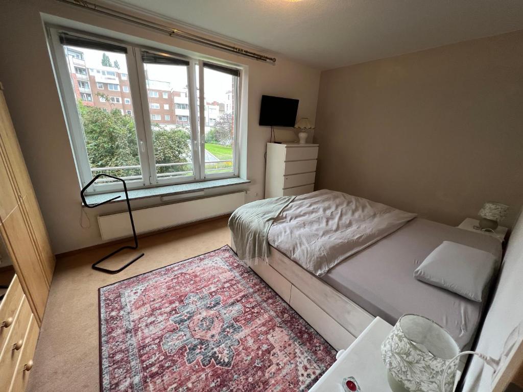 a bedroom with a bed and a large window at Zwischen Drägerpark und dem Stadtpark in Lübeck