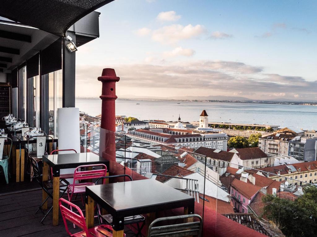 balkon ze stołami i krzesłami oraz widokiem na miasto w obiekcie Monte Belvedere Hotel by Shiadu w Lizbonie