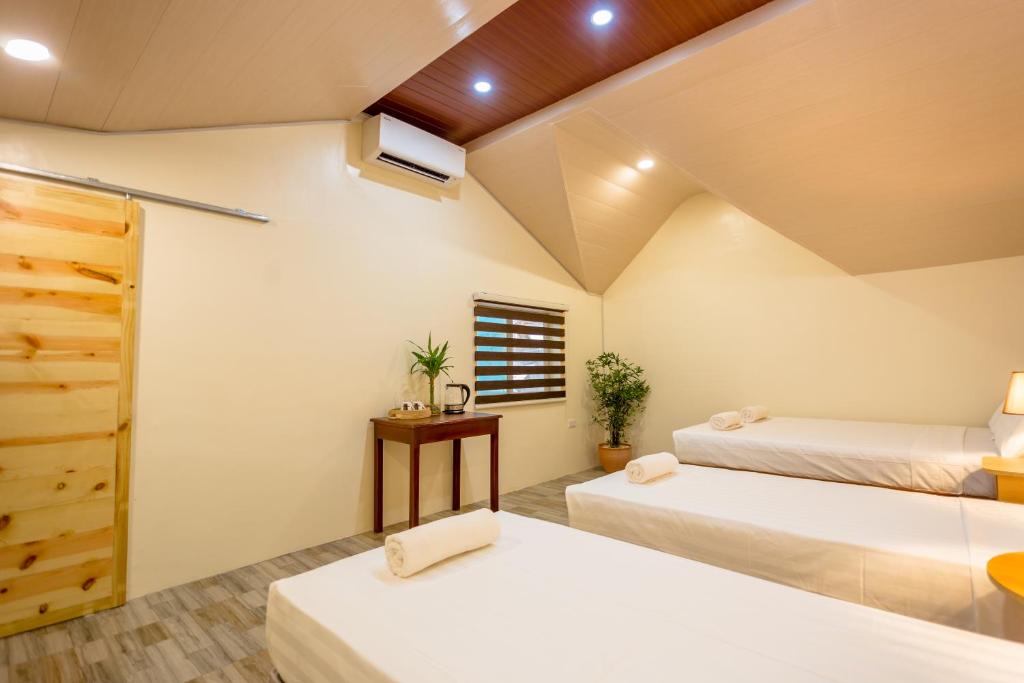 Habitación con 2 camas y ventana en ALONA BEACH SIDE INN, en Panglao
