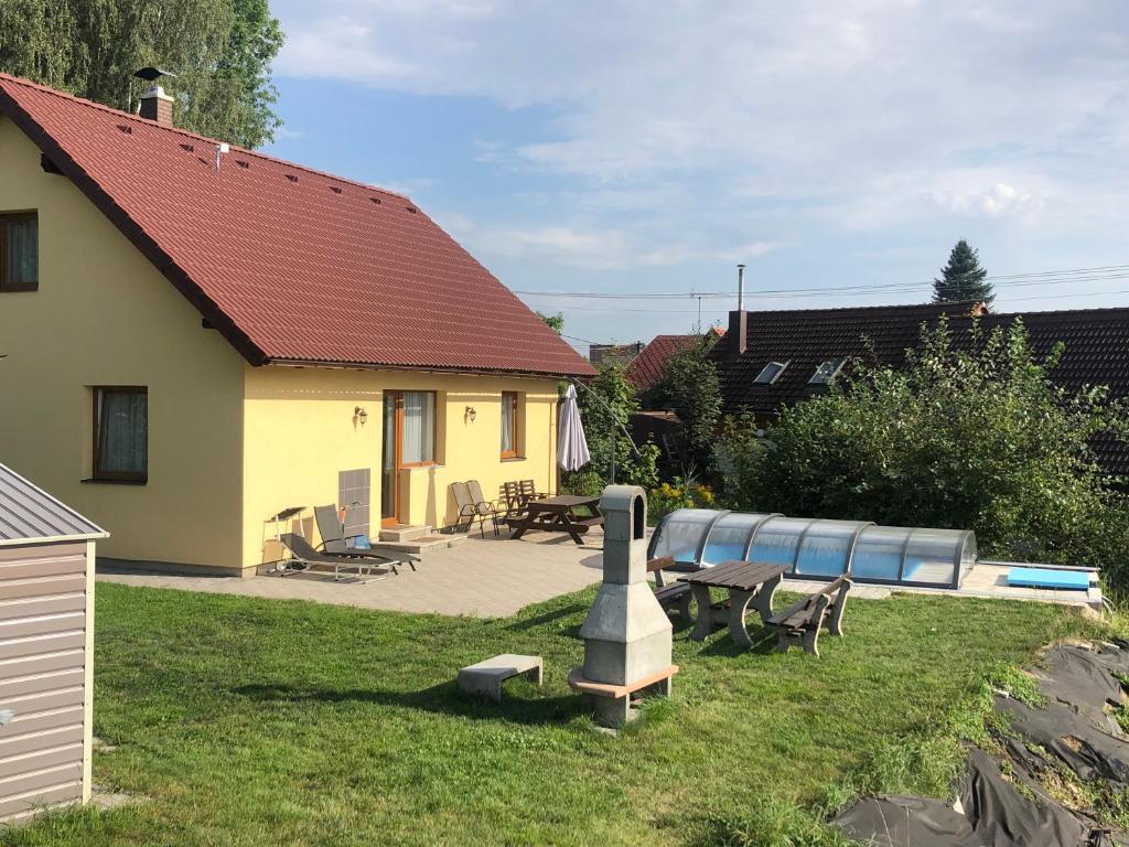 a backyard with a house with a pool and picnic tables at Baráček–Český ráj in Turnov