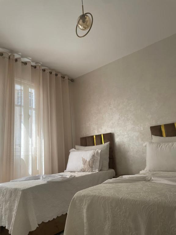 een slaapkamer met 2 bedden en een raam bij Kenza house place in Casablanca
