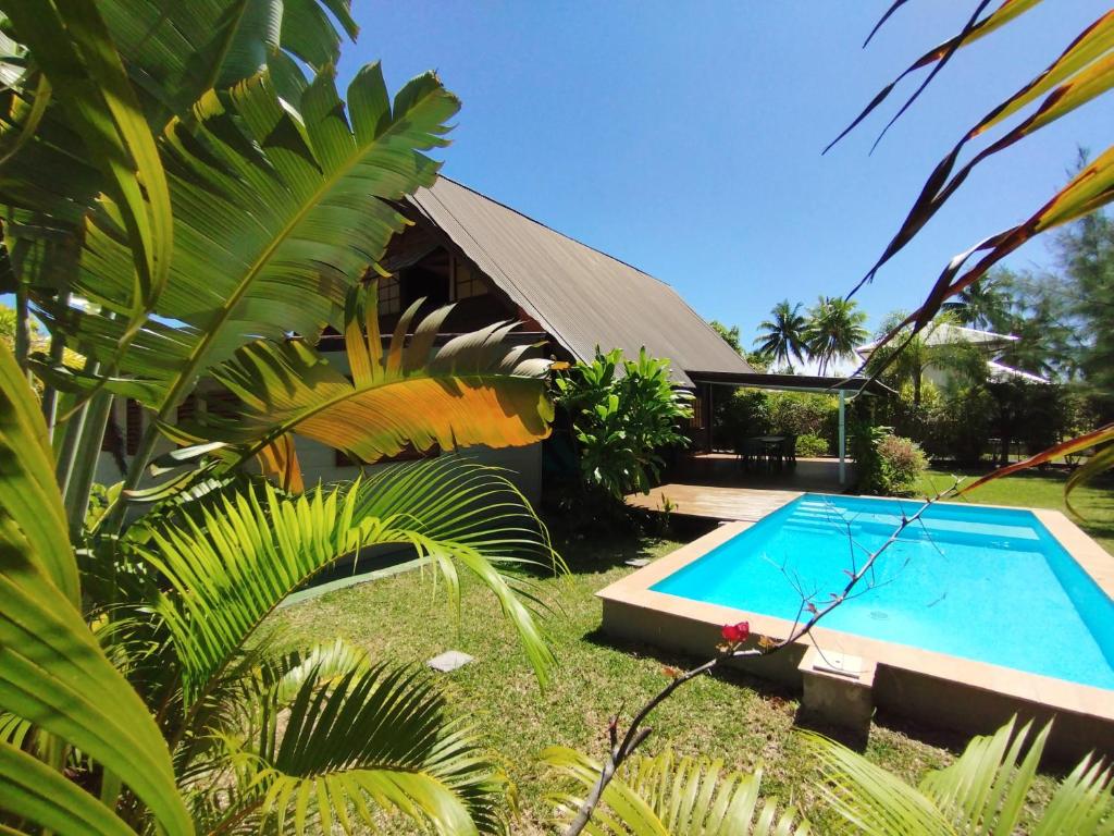a swimming pool in the yard of a house at Moorea Pool & Lagoon House in Moorea