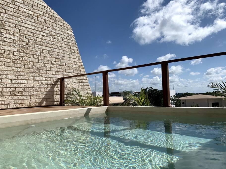 uma piscina em frente a uma parede de tijolos em Chic PH Private Pool/Rooftop near to beachfront em Tulum