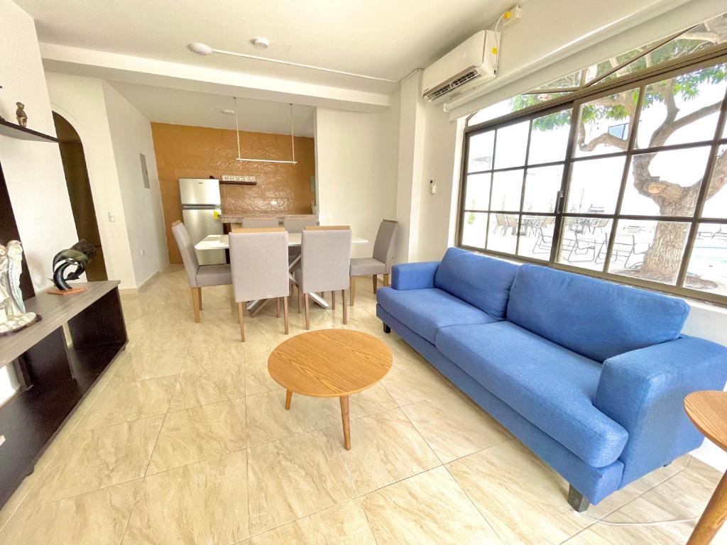 sala de estar con sofá azul y mesa en Hermoso Departamento en Lomas de Barbasquillo, en Manta