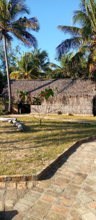 un parco con palme e un sentiero in pietra di Povoado Bitonga a Inhambane