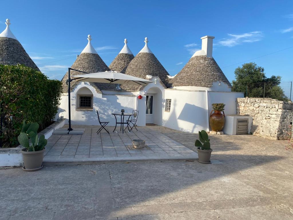 a white house with a patio with a table at Trulli Mamima in Martina Franca
