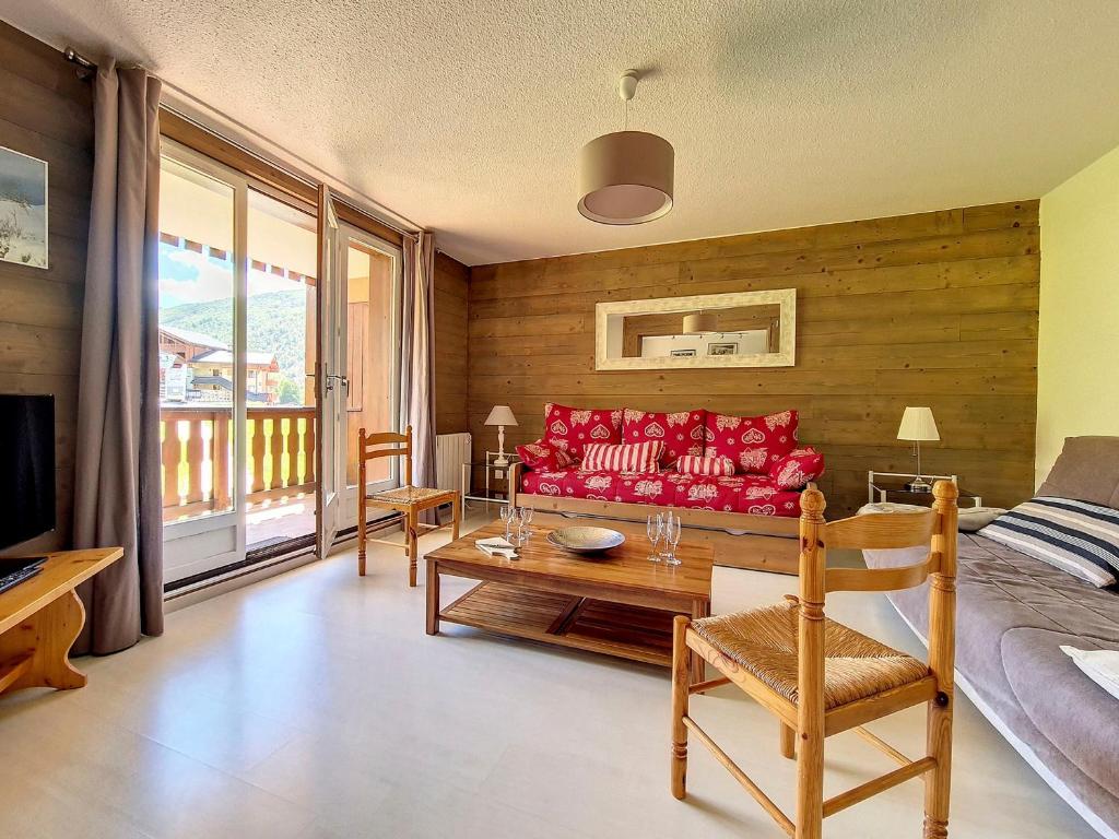 un salon avec un canapé rouge et une table dans l'établissement Spacieux appartement 3 pièces au pied des pistes avec balcon - FR-1-344-968, à Saint-Martin-de-Belleville
