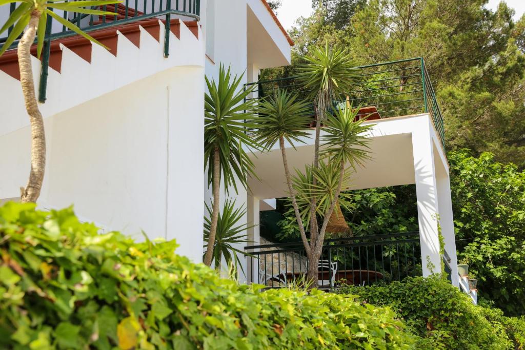 a white building with a staircase and plants at Es Cucó in Cala Galdana