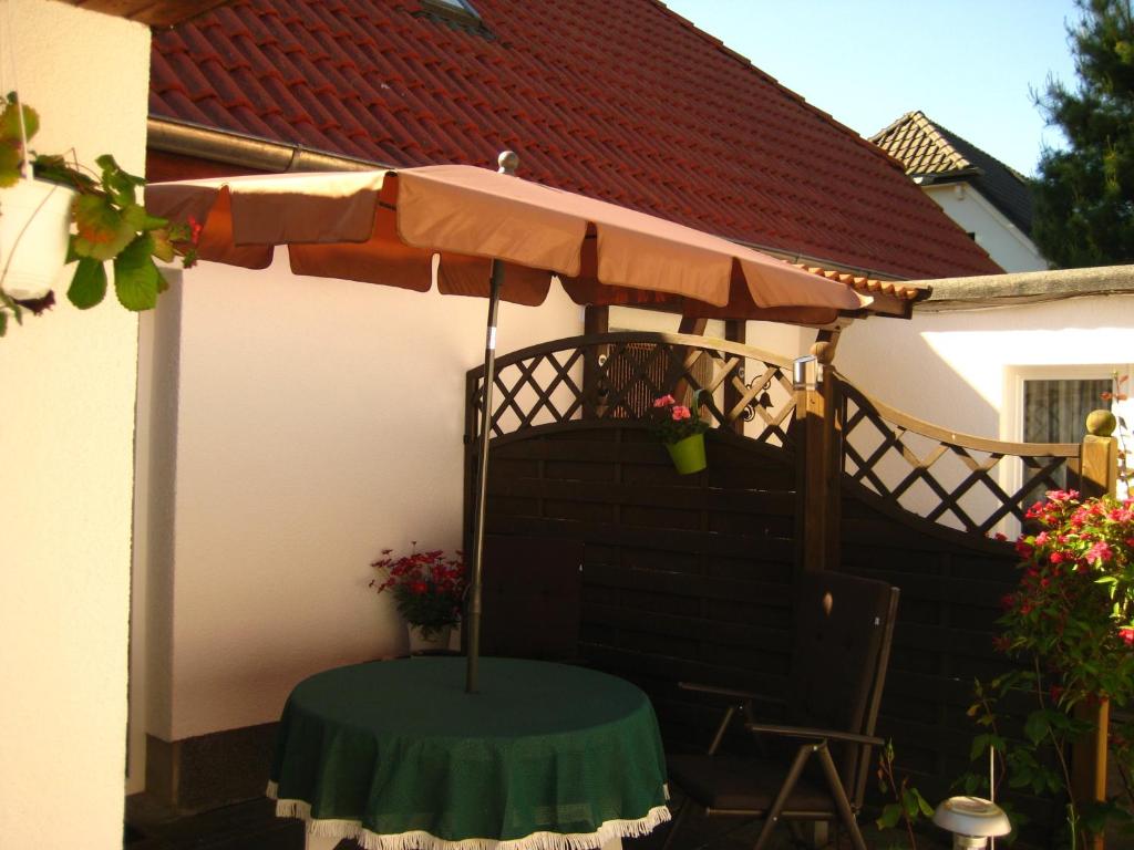 eine Terrasse mit einem Tisch und einem Sonnenschirm in der Unterkunft Ferienhaus Abendsonne in Born