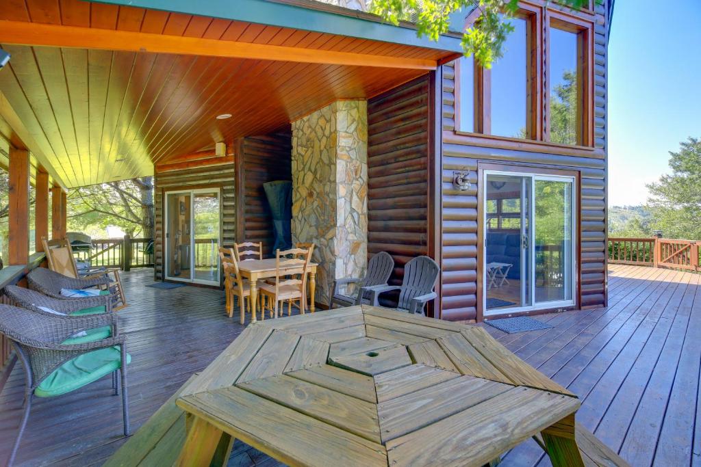 a wooden house with a table and chairs on a deck at Piney Creek Cabin with Deck, Grill and Mountain Views! in Piney Creek