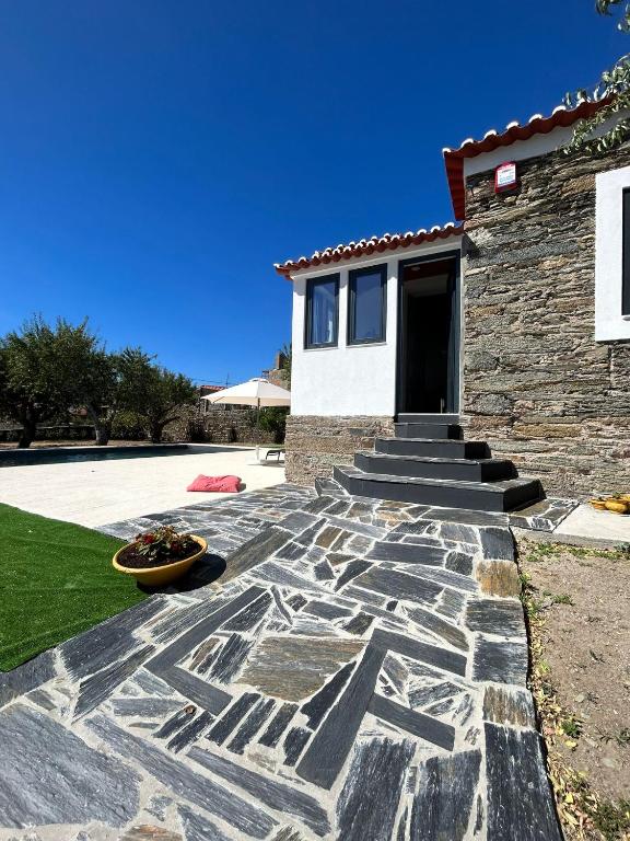 a house with a stone pathway in front of a house at Domus Vila Maria Douro in Castanheiro do Sul