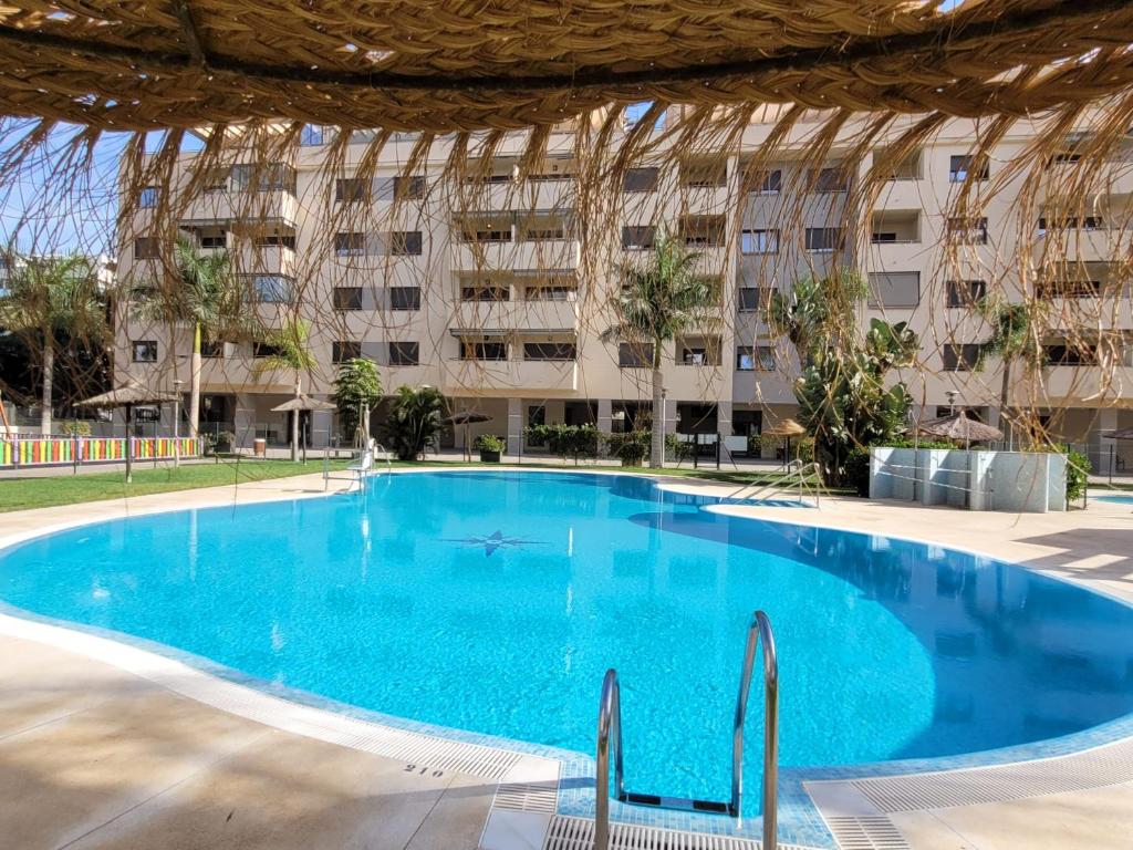 an empty swimming pool in front of a building at LA MARINA in Torre del Mar