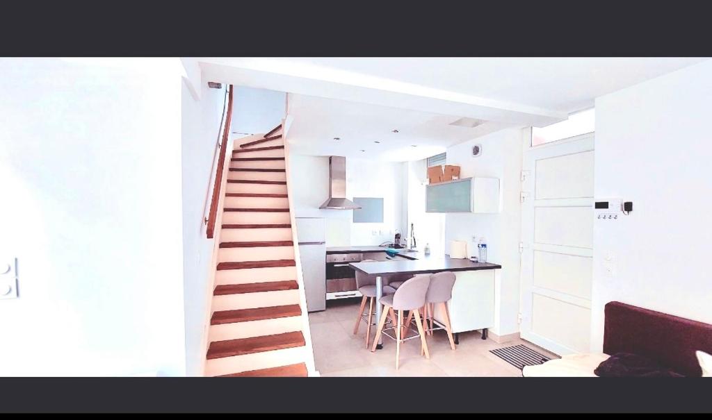 eine Treppe, die zu einer Küche mit einem Tisch führt in der Unterkunft Maison de charme en centre ville avec terrasse in Lille