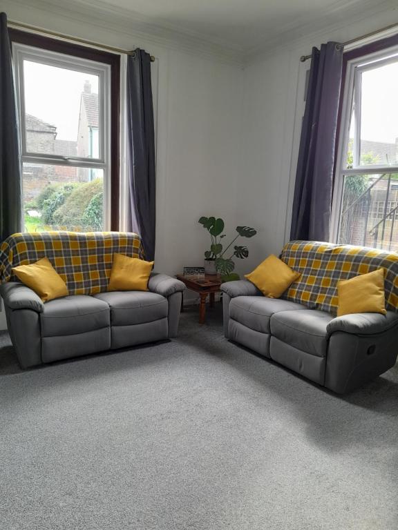 a living room with two couches and two windows at Home from Home in Faversham