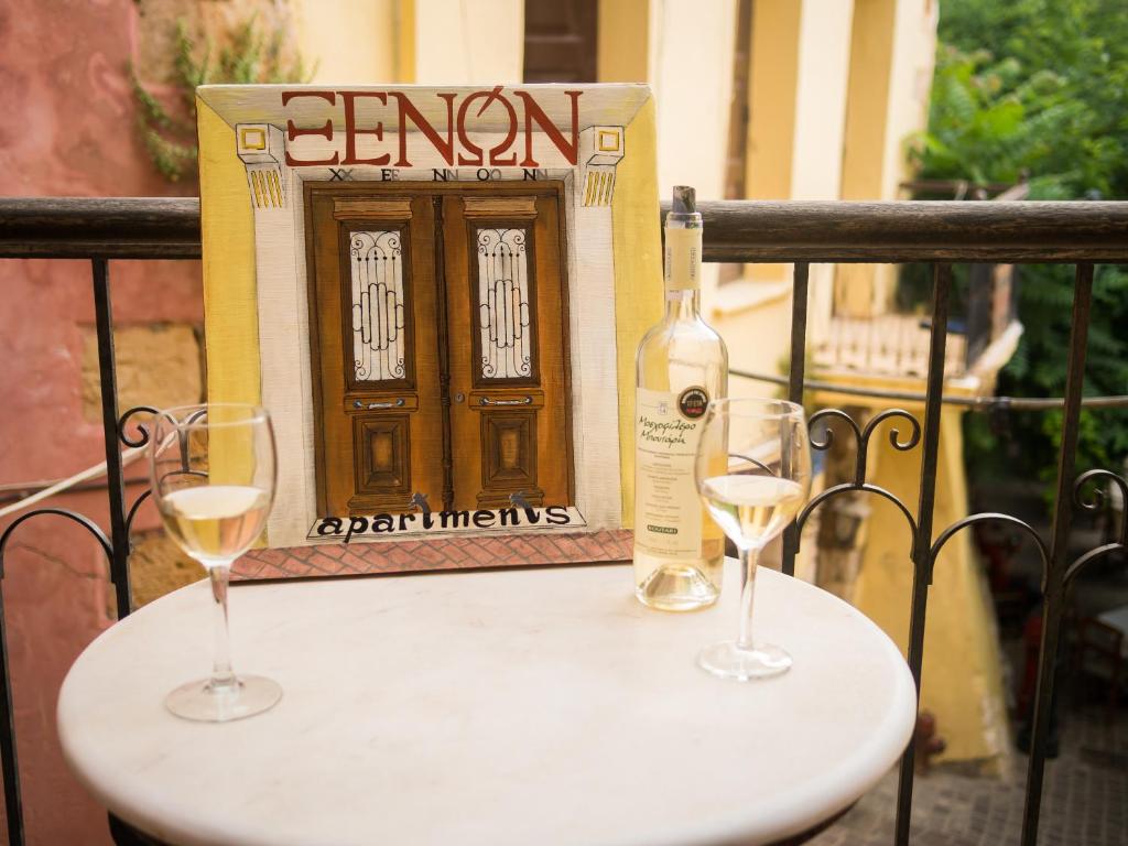 Una botella de vino y dos copas en una mesa. en Xenon Apartments, en La Canea