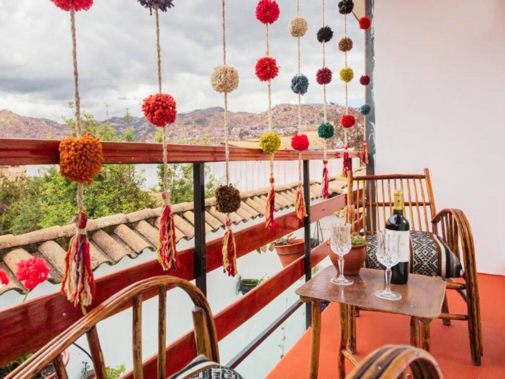 een kamer met een balkon met een tafel en stoelen bij Hotel Andean Host Inn in Cuzco