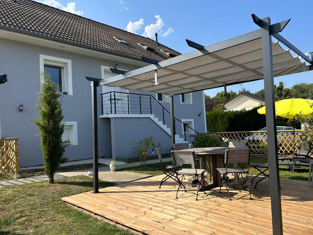 un patio con mesa y sombrilla en Le Cosy Home Annecy, en La Balme-de-Sillingy